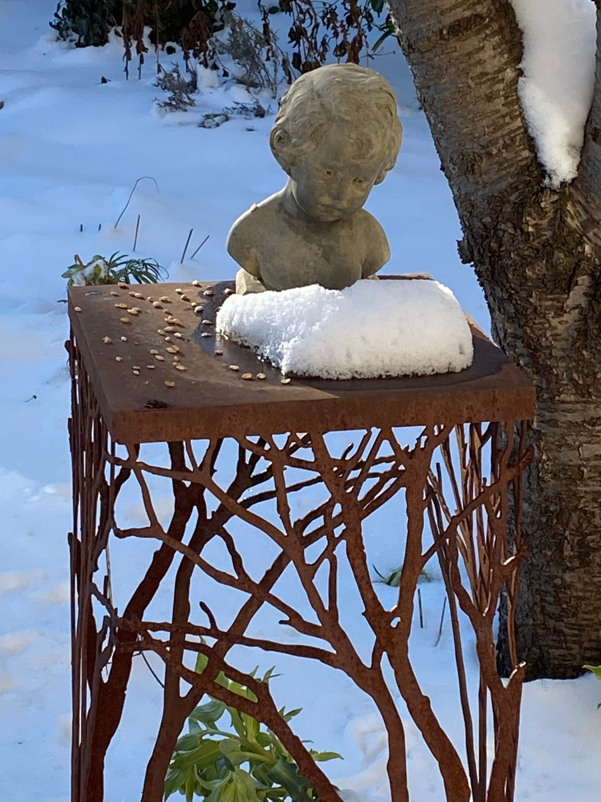 Skulptur im verschneiten Garten