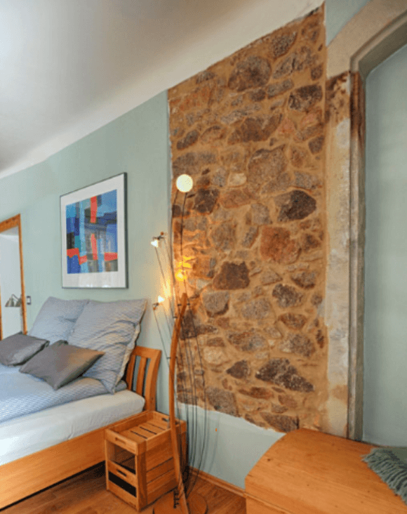 Schlafzimmer mit historischer Bruchsteinwand